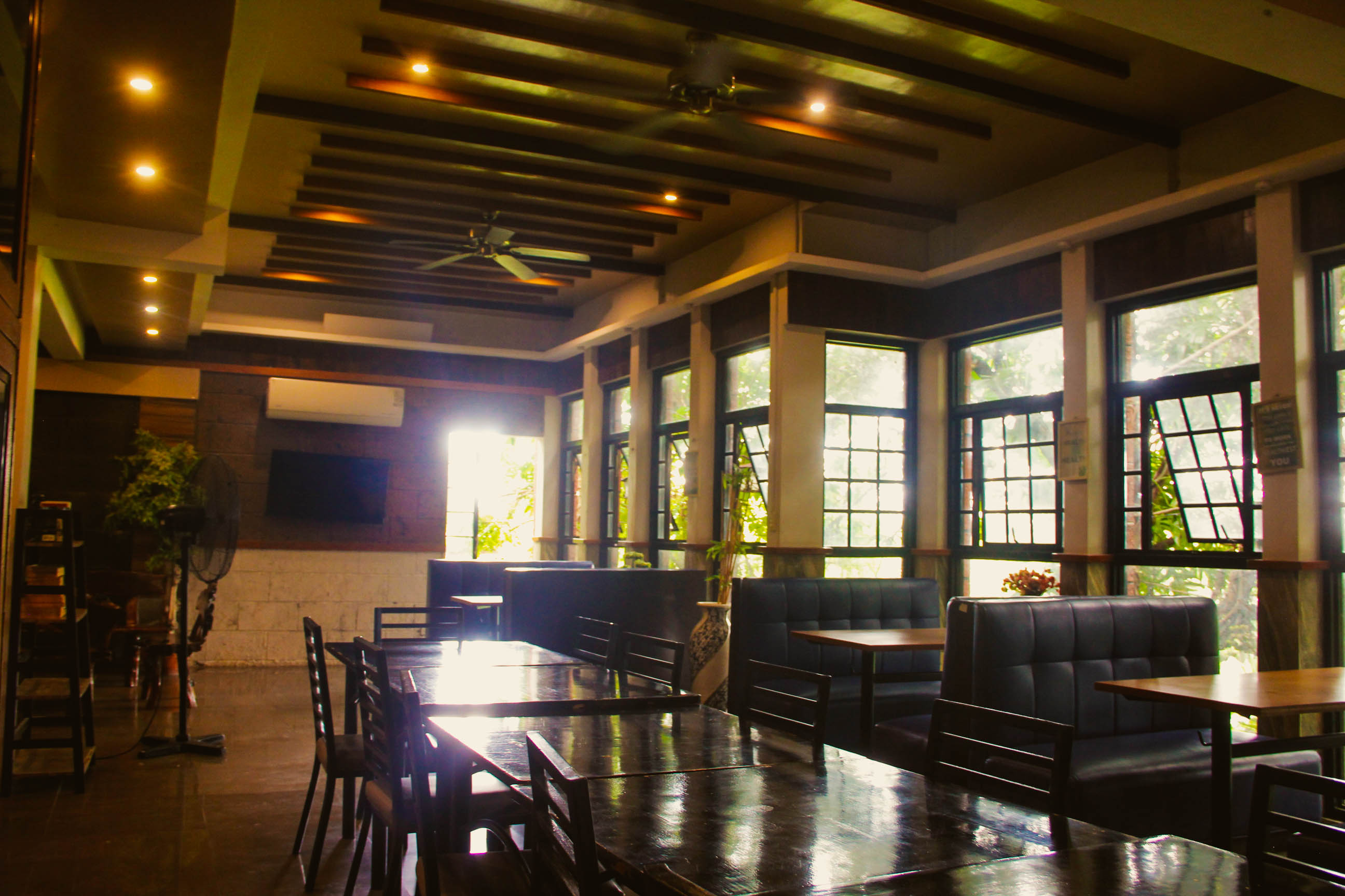 The resto's dining room, with tables and tall windows looking out on the trees